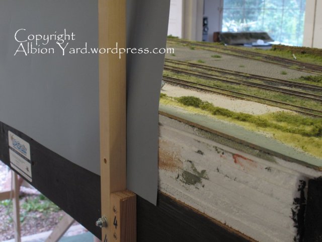 The stantions sandwich the print between baseboard and support