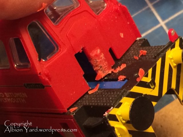 Slicing sections from around the screw to release it.